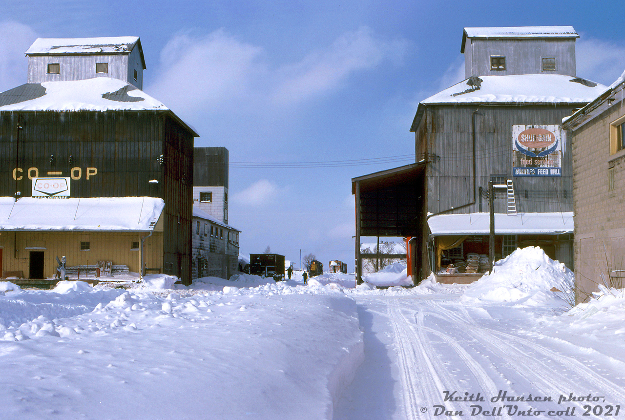 One of those rare instances where Algoma Central power made it to Orangeville and Owen Sound: ACR GP7 154, one of two units leased to CP for a few months in 1978-1979, was typically used by CP on roadswitchers, transfers and local jobs in and around the Toronto area. Today however, 154 found itself working The Moonlight northbound on CP's Orangeville/Owen Sound Subs. The unit is seen framed between the Farmers Co-Op and Rundles Feed Mill (Shur-Gain) elevators at Dundalk, after having uncoupling its train and backing to lift a single hopper from the Co-Op "coal pile" siding as the crew watches on. From the few other photos I've seen from this outing, the unit ran a plow extra southbound the next day.

The tracks were lifted through Dundalk in the mid-90's when the Owen Sound Sub north of Orangeville was abandoned, but the elevator on the left survives today. On the site of the other elevator? A very railway station-esque building housing the Southgate Ruth Hargrave Memorial Public Library.

Keith Hansen photo, Dan Dell'Unto collection slide.
