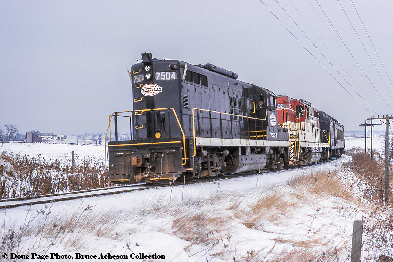 January 14, 1967 was a special day for fans of the Toronto Hamilton & Buffalo Railway, as the Upper Canada Railway Society ran an excursion covering TH&B and NYC lines (NYC owning 73% of the TH&B, CPR the other 27%) in Southern Ontario, and included utilizing an NYC GP9 on the point. Here, the train crests the grade at Summit near Copetown on the Waterford Subdivision on the first leg of the trip from Hamilton - Waterford. From there, the train will run east on the NYC's CASO to Welland, where it will turn back west on the TH&B going Welland - Hamilton.Bill Thomson was standing just across the tracks from Doug here.More Waterford Sub at Copetown:B&O on the steel train, Arnold Mooney, November 1983.Chessie at Highway 99, Arnold Mooney, November 1983.Chessie at Highway 52, Arnold Mooney, November 1983.Westbound C424s, Arnold Mooney, December 1983.Sunny steel train by the muskeg, Dave Stowe, April 1984.Doug Page Photo, Bruce Acheson Collection Slide.