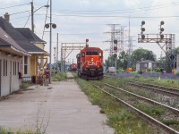 A pair of light engines pause alongside the old Burlington West station waiting for the approaching movement to crossover to the north track and likely onto the Halton Sub.  Crews are seen onsite at the station taking care of some work, potentially prepping for future use.  Estimated date of late summer 2004, as the station would be <a href=http://www.railpictures.ca/?attachment_id=44580>up and rolling in May 2005.</a>  Today the station sits just a bit further west along Fairview Street and is well <a href=http://www.railpictures.ca/?attachment_id=34977>preserved by the Friends of Freeman Station.</a>