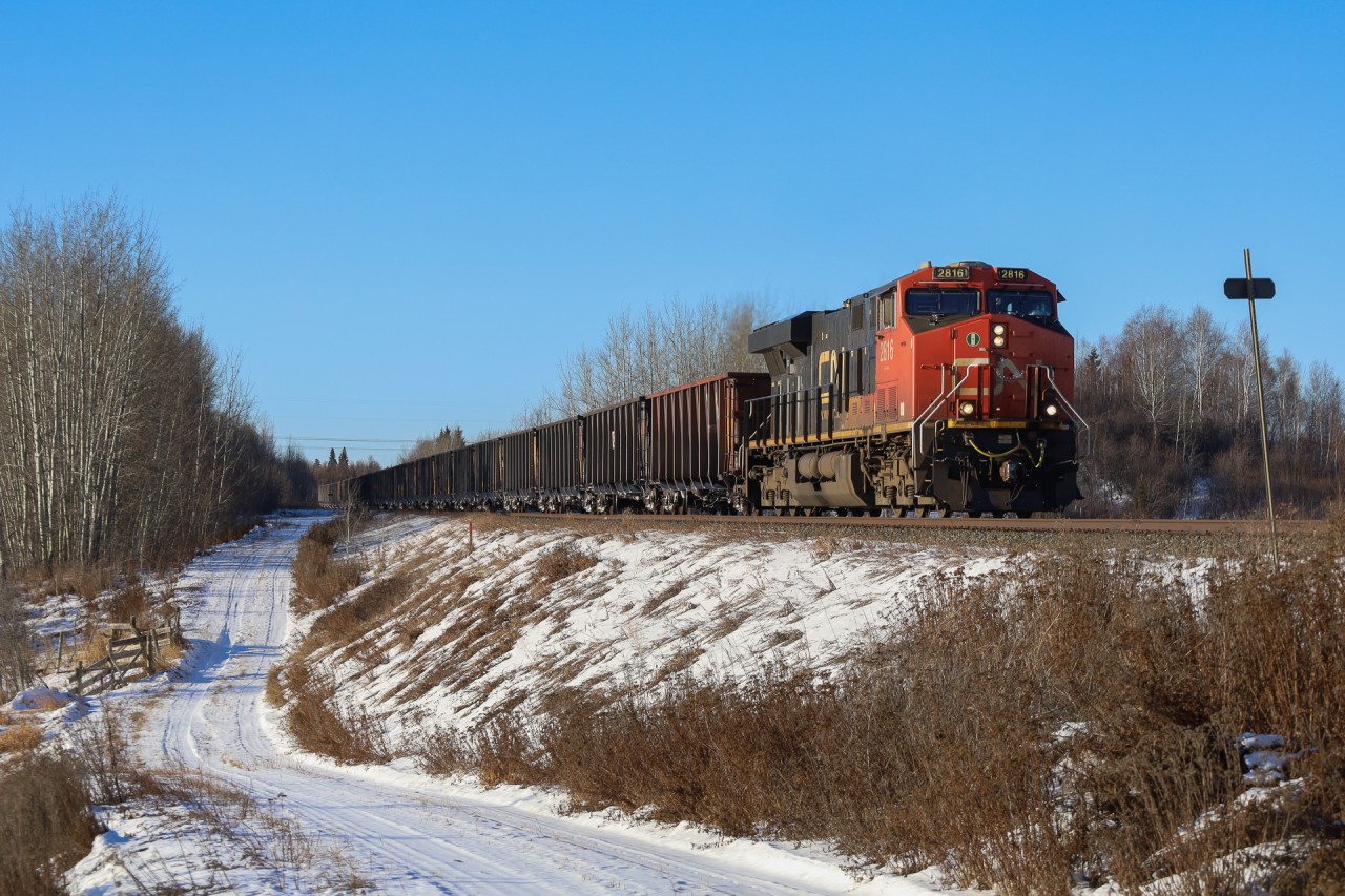 CN U 77851 03 rolls through Kapasiwin, just east of Wabamun with CN 2816 and 153 cars.  U 778 operates from Prince Rupert, BC to Keenan, Minnesota;  The train will return loaded with ore from the DM&IR Iron Range, for export to Asia.