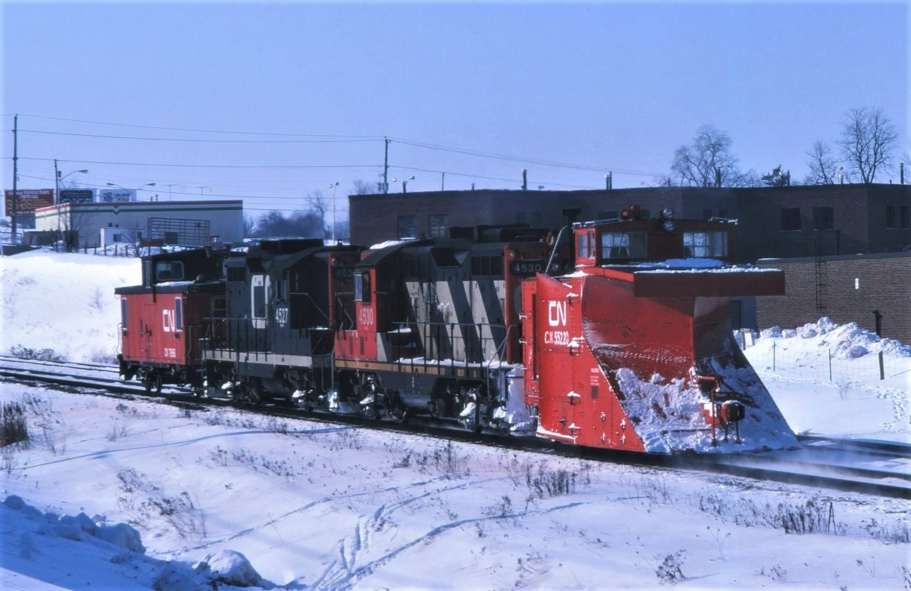 Plow extra 4530 heads back to Toronto Yard with the caboose leading the way.  If you look carefully, you can see the snow blowing up in front of the plow! The train most likely had been plowing the Uxbridge Sub.  Consist includes GP9s 4530 and 4527, plow 55220, and an unknown caboose.