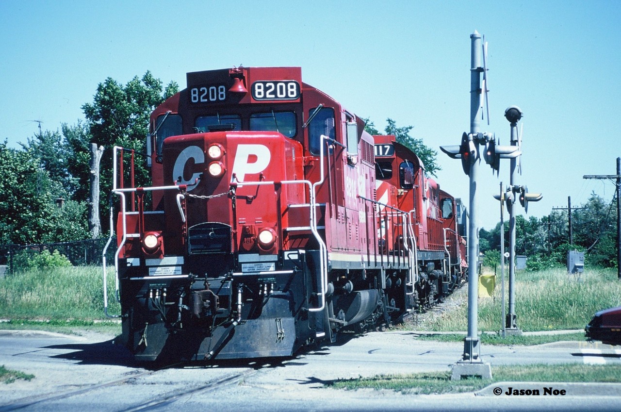 During the summer of 1997, a friend and I decided we needed to attempt to photograph the Canadian Pacific “Moonlight” on what remained of the CP Owen Sound Subdivision between Streetsville and Orangeville. At the time it was a spare-board assignment out of Lambton Yard in Toronto and if memory serves it was ordered at 13:00 on Monday-Wednesday-Friday. 

After a couple failed attempts, on Monday, July 7 the Moonlight Job arrived in Streetsville with CP 8208, 1117 and 8243 at 14:45 according to my notes. From there the chase would begin. With mid-day summer sun still an issue we headed north hoping for better angles. Here at Mile 8 in Brampton, the Moonlight is viewed heading north at the double crossings at Williams Parkway, which still today have CPR stamped on the signal posts according to Google Street View.