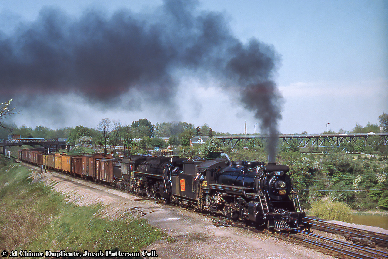 With helper 3509 tied on, CNR Extra 6217 west departs Bayview Junction taking the switch to the Dundas Subdivision.  The consist includes a number of outside braced wooden boxcars and Pacific Fruit Express reefers (some empty with open hatches).CNR S-1-g, 2-8-2 Mikado 3509 was built by the Canadian Locomotive Company of Kingston in 1917 for the Grand Trunk as 489.  It would receive the number 3509 during the 1923 consolidation under the Canadian National Railway, and would be scrapped in March 1960.  CNR U-2-g, 4-8-4 Northern 6217 built by MLW in September 1942 and would be scrapped in July 1961.Original Photographer Unknown, Al Chione Duplicate, Jacob Patterson Collection Slide.
