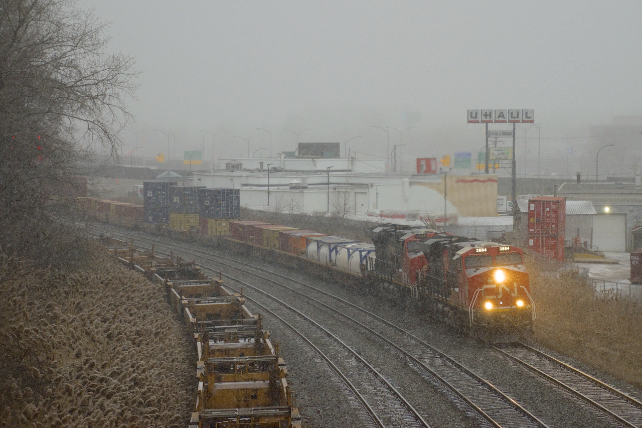 The snow has started to fall as CN 123 heads west with CN 3884 & CN 2868 for power after a crew change at Turcot Ouest.