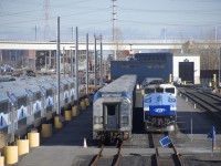 Multilevel cars as well as stored MR-90 cars are visible at the Pointe-Saint-Charles Maintenance Centre, with AMT 1347 at the front of a Mascouche trainset at right. Barely visible at left is EXO 808, heading towards the Victoria Bridge.