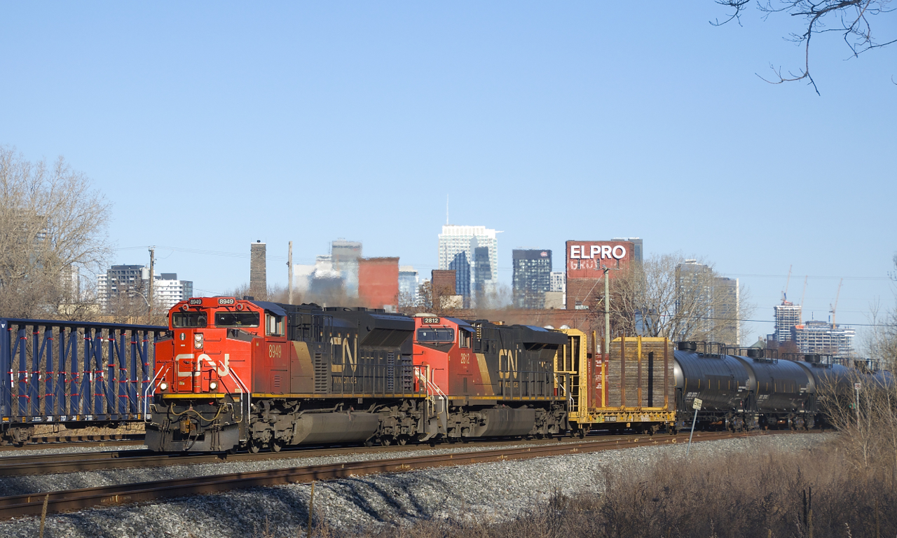 CN 305 is passing a parked CN X306 as it passes underneath the skyline of downtown Montreal with CN 8949 & CN 2812 up front.