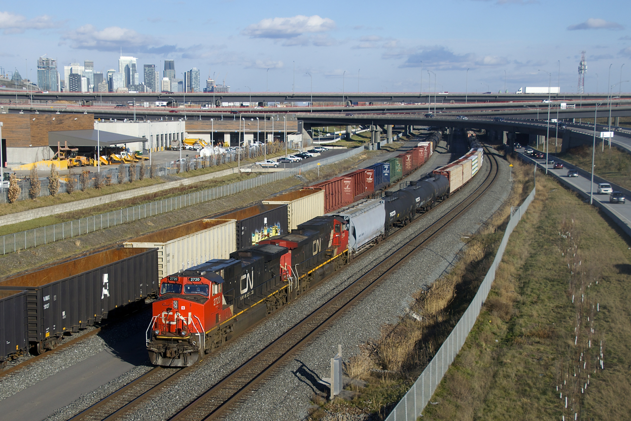 CN 305 has a pair of Dash9s for power (IC 2720 & CN 2564) as it approaches Turcot Ouest. There it will set off the first 23 cars and continue west as a solid train of potash empties (175 of them). At left is a parked CN X306.