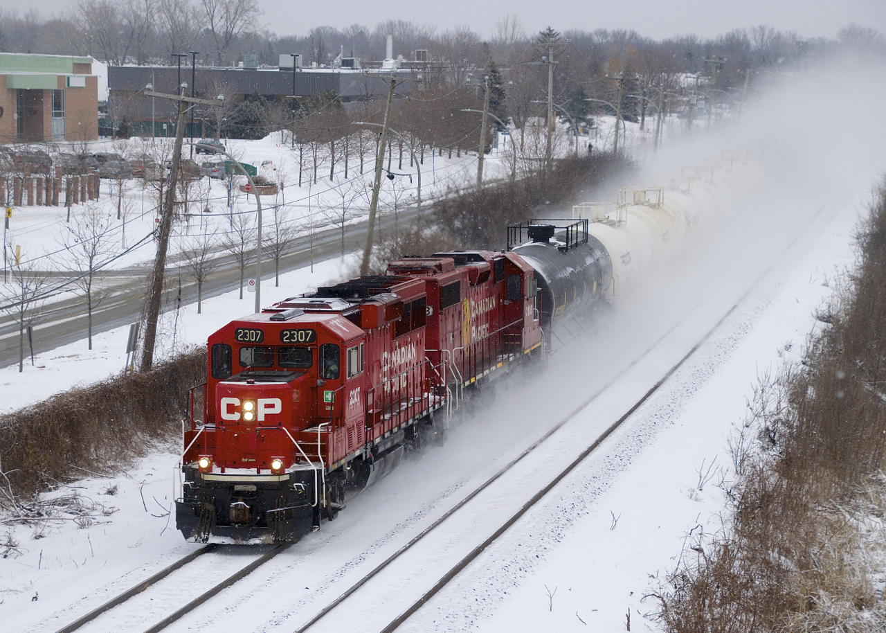 CP F95 is kicking up quite a bit of snow as it rockets through Point-Claire with CP 2307, CP 3108 and nine tank cars.