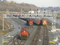 CN 305's leader has just dropped off the two trailing units on the freight track and is now heading west so that it can back onto its train (stopped on the north track). Meanwhile CN 527 is passing on the south track. The fourth track at left (track 29) is occupied as well, with numerours cars parked there.