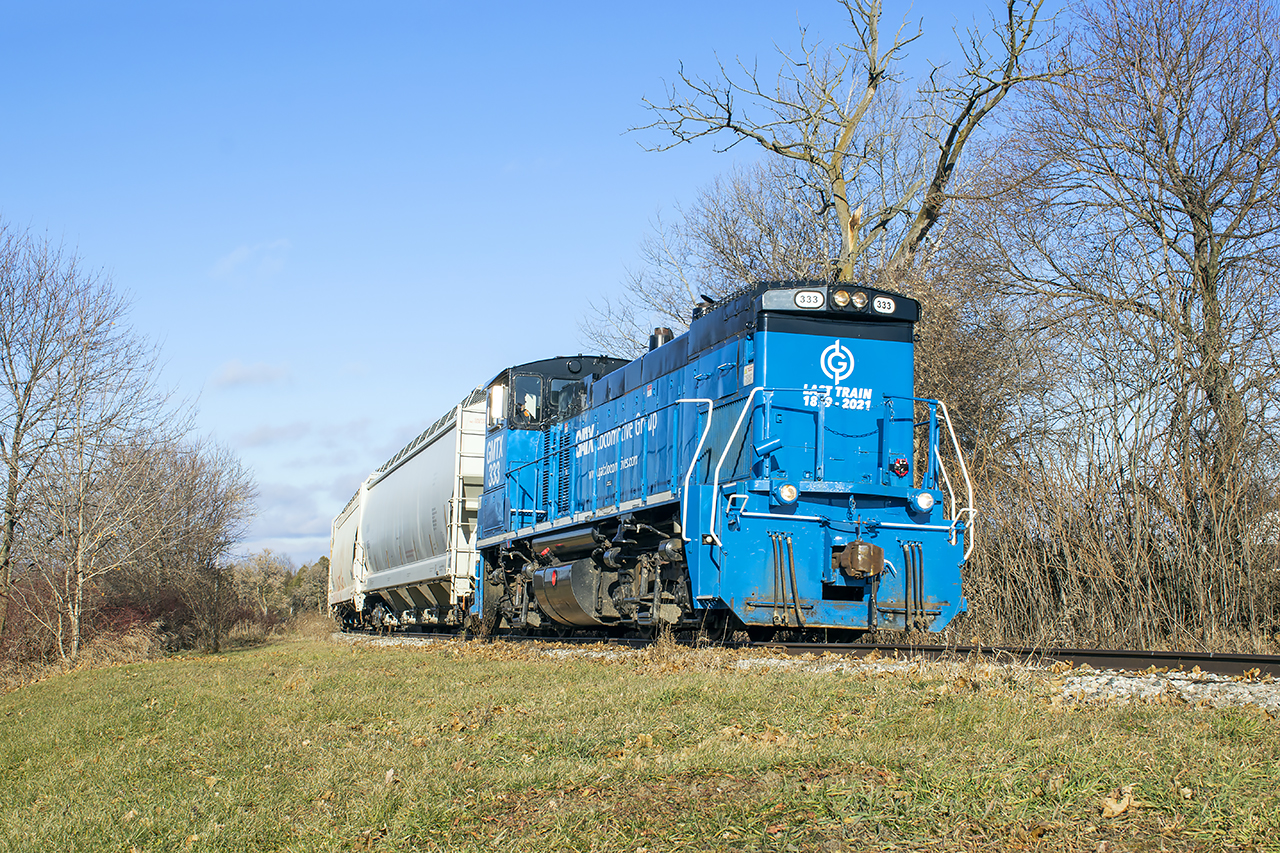 Last call.  The Orangeville Brampton Railway is southbound into the curve just east of Cheltenham with a pile of photographers documenting the final journey.  Immediately to my right, the joints on 1921 stamped rail clink together beneath the passing weight and calmly settle one last time.  Management from GIO Rail, Trillium Railway's holding company, have applied their logo to the front of the "triple 3" with the Owen Sound spur's dates of operation... 1879 - 2021.  The first train departed Orangeville December 2, 1879, and the final one 142 years, 15 days later.The OBRY caboose left the property by truck about a month ago, now a private residence near Bala.  The ballast hopper too is sold and will leave by truck.  Note the phone taped to the MU cover... someone has documented some great views of the line.