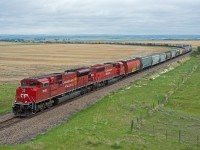 Two CP EMDs are down to a crawl as they drag a loaded grain train upgrade out of Seven Persons Alberta on the Taber Sub.  Behind 7043 and 6258 the entire 110 care train can be seen, along with UP 7619 pushing on the rear. Despite being the May long weekend and June being right around the corner, there is still a trace of snow on the ground. 