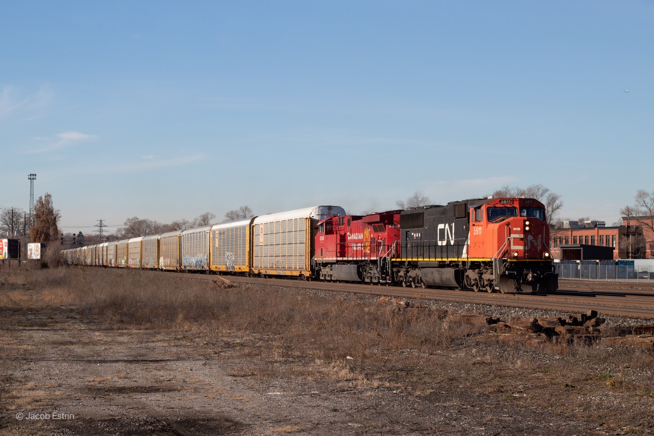 CN 5611 is seen on point of CP 244 as it passes Scarlett on the approach to West Toronto where it will tie down and later turn into 2-T49 under a new crew.

This train would've been in perfect light through here but unfortunately there was a screw up with a cut of cars around Hornby. The plan was to leave a cut of 26 cars in a spare track at Hornby where 246 would then pick them up and take them down the Hamilton for they're destination. Unfortunately Hornby was not going to take them and they had to make another plan. What ended up happening is 246 pull West of the signals at Cooksville, 244 left they're train on the main and backed the 26 cars onto 246's train. After that they backed up back onto they're train and proceeded East.

As they were approaching West Toronto they came to a stop, all radio chatter went silent and they did not have a signal to proceed past towards Davenport, RTC JD then told the crew to tie down and that they're train would turn into a 2-T49 and head North on the Mactier later in the day.