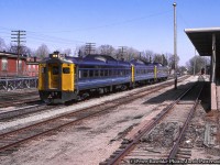 VIA Rail train 663 is passing through Guelph with a trio of Budd RDC's in the consist, led by RDC-1 6113, now preserved by the <a href=https://viahistory.ca/home/>VIA Historical Association</a>. The train is seen trundling past the Guelph Twines building at left and the CN express building to the right. Today the CN express building is owned by Granite Homes serving as office space for various companies. Note the walkways alongside the TOFC (Trailer on Flat Car) loading ramps at left.<br><br>At left the Guelph Twines Building has a fair bit of history behind it. Built circa 1903 (per 1897 - 1907 fire insurance maps) as the headquarters of the Louden Machinery Company of Canada Ltd. and branded as “The Largest Factory under the British Flag devoted exclusively to the manufacture of Barn and Stable Equipment.” By the late 1920's the building became part of Leland Electric, coming under control of Sangamo Electric circa 1960. Sangamo would in turn become part of Prestolite in 1970, who occupy the building until 1972 when a twine company from Brantford relocated to Guelph, becoming Guelph Twines.<br><br><i>Peter Raschke Photo, Jacob Patterson Collection Slide.</i>