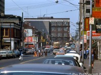 One for the 70's automotive enthusiast: TTC Peter Witt streetcar 2766 trundles down Dundas Street in Tour Tram service, during a warm bustling Summer afternoon in downtown Toronto. This telephoto image was shot looking west on Dundas from Bay towards University Avenue in the distance (the big brown building was originally the Ontario Veterinary College, later The Province of Ontario Savings Branch). 
<br><br>
Street signs, many advertising Chinese businesses, jut out from streetside storefronts along Dundas Street. This area used to be Toronto's old Chinatown, but due to nearby development of the new City Hall in the 60's (that expropriated many buildings to the south along Elizabeth Street in <a href=http://www.railpictures.ca/?attachment_id=45789><b>"The Ward"</b></a>) many of the Asian-run businesses moved to a "new" Chinatown focused around Spadina and Dundas.
<br><br>
<i>Original photographer unknown, Dan Dell'Unto collection slide.</i>