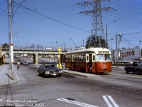 During her last year in service, TTC PCC 4764 (an A14-class car built in 1946 by St. Louis Car for Kansas City, Missouri) pauses along the St. Clair route at the platform stop at Prescott Avenue, just west of the 1931-built CN Newmarket Sub bridge.<br><br>Pre-1931, the CN Newmarket Sub crossed St. Clair Avenue here at-grade, and streetcars terminated at loops on either side of the crossing, necessitating riders to de-board, cross the tracks, and board another streetcar to continue further (the Dovercourt streetcar terminated here at the west side at Prescott Loop, and the St. Clair car terminated on the east side at Caledonia Loop). The construction of this bridge/underpass/grade separation in 1931 (and re-alignment of the Newmarket Sub, and new <a href=http://www.railpictures.ca/?attachment_id=34053><b>CN St. Clair Avenue station</b></a>) allowed the St. Clair streetcar tracks to join and eliminated all the inconvenient loops and transfers for passengers.<br><br>The TTC's A14 ex-Kansas City cars were some of the first secondhand PCC's to leave the roster due to lackluster maintenance from their original owner. Car 4764 was one of 11 sold to MUNI in San Francisco to operate until their new cars were delivered. Renumbered 1184, she never ran in service and was reportedly used as a parts car.<br><br><i>T. Shepherd photo, Dan Dell'Unto collection slide.</i>