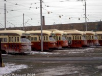 Various flavours of Toronto Transit Commission PCC's crowd the yard tracks of Roncesvalles Carhouse on a wintery day in mid-February 1973, waiting their next trip out on routes such as King, Queen, and Carlton that were run out of Roncesvalles (Roncesvalles on the destination roller blind instead of one of the normal endpoint usually meant a car was short-turning or going out of service at that street, and returning to the carhouse). From left to right are an A6-class car (43xx), A7 (4400), two ex-Cleveland A11's (46xx, the first fully repainted in subway red), another A6 (recently rebuilt and sporting a water bumper) and an A7. Couplers on some cars (44xx (A7) and 46xx (A11)) were for MU service on the busy Queen route. Road salt and brine coat a few of the cars that have been out in service, others have recently visited the wash rack and are a bit cleaner. Needless to say, decades of winter service on Toronto roads did not bode well for the condition of many cars at the ends of their service lives.<br><br><i>Original photographer unknown, Dan Dell'Unto collection slide.</i>