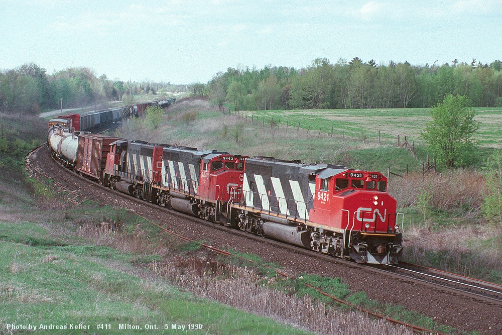 Macmillan Yard - Sarnia train 411 rounding the curve at Mile 30 with a trio of GMD GP40-2W's. CN 9421, CN 9443, and an unidentified third unit are showing the way