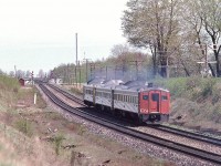 <br>
<br>
   At track speed a High Green at Newtonville for daily except Saturday #652, aka 'Ontarian'
<br>
<br>
   Scheduling allowed daily trains #651 ex Sun, #652 ex Sat, #655 ex Sat and #656 ex Sat, between Union and Kingston, to be handled by one set of Budd Cars for two round trips daily except as noted.
<br>
<br>
   A Nikkor 200mm F4 view from the bee bridge ( Nichols Road) of the Newtonville crossover May 13, 1979 Kodachrome by S.Danko
<br>
<br>
   Notable: seems to me that the Budd Company built rail diesel cars likely were the most fuel efficient heavy rail equipment ever created, capable of carrying ninety seated passengers and crew at up to ninety miles per hour: a Budd Car's fuel consumption measured in miles per gallon verses other heavy rail transport fuel usage being measured in gallons per mile. 
<br>
<br>
   Noteworthy: sometime in the nineties the wooden bee bridge was reportedly damaged by a CN freight car's shifted load.  
<br>
<br>
   Notable: The smoke stack denotes the location of the uncompleted Ontario Hydro Wesleyville power generation plant. The plan was have the fuel oil delivered by tanker train – the siding tracks remained in place for quite some time. Throughout the decades the plant building and grounds have been used for film shoots and for fire fighter training.
<br>
<br>
   sdfourty 