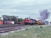 <br>
<br>
    MLW's rule ! 
<br>
<br>
    VIA CN FPA-4  #6789, VIA CN FPB-4 #6865 and CN RS-18 #3105  have the morning Capital / Lakeshore, trains 43 / 53, on the move, 
<br>
<br>
    Accelerating from the Cobourg station stop, June 23 1979 Kodachrome by S.Danko
<br>
<br>
    interesting:
 <br>
<br>
    at left note the livestock loading pen and ramp, CN work train caboose and rail transport work car, 
<br>
<br>
    and the main line ribbon rail looks relatively new, 
<br>
<br>
    at extreme right is my '77 Impala, and above the Impala is the CP Rail westbound searchlight home signal for the CN  Cobourg Town Spur (CTS) interlocking at CP Rail Belleville Subdivision mile 135.2:
<br>
<br>		
    CTS: Switch points face west from CN track KS12 (south service), interlocking controlled by the CP Rail Train Dispatcher.
<br>
<br>
    CTS: Originally the Cobourg Railway Company incorporated 1834, commenced operation 1853 ( three years prior to the GTR ( now the CN Kingston Sub.) completion)  as the Cobourg & Peterborough Railway (C&P). The 2 mile causeway and bridge over Rice Lake was problematic and by 1866 the railway was re-routed east of the Lake and renamed the Cobourg Peterborough and Marmora Railway (CPM) 
<br>
<br>
    The industrial tracks on the north side of the Kingston Subdivision were known as the Cobourg Yard, now known as Cobourg.
   <br>
<br>
    sdfourty
