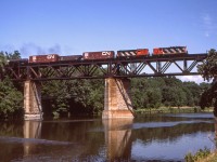 An eastbound CN freight is crossing the Grand River in Paris, Ontario on August 9, 1985. I believe the lead unit is CN 4534 but can't be certain because of the shadow on the number.