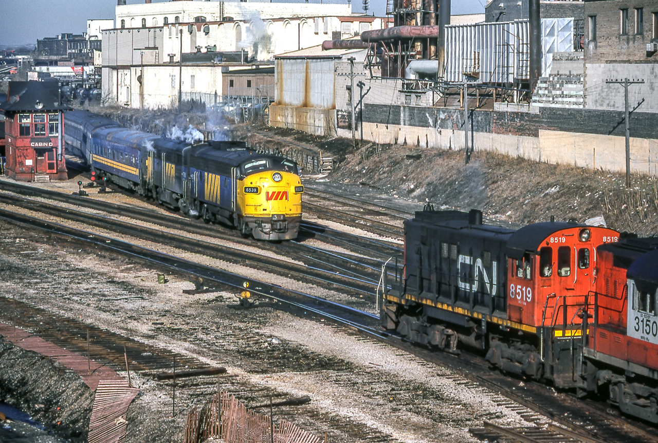 VIA 6539 has an eastbound meet with CN 8519 at Cabin D in Toronto on March 23, 1982.