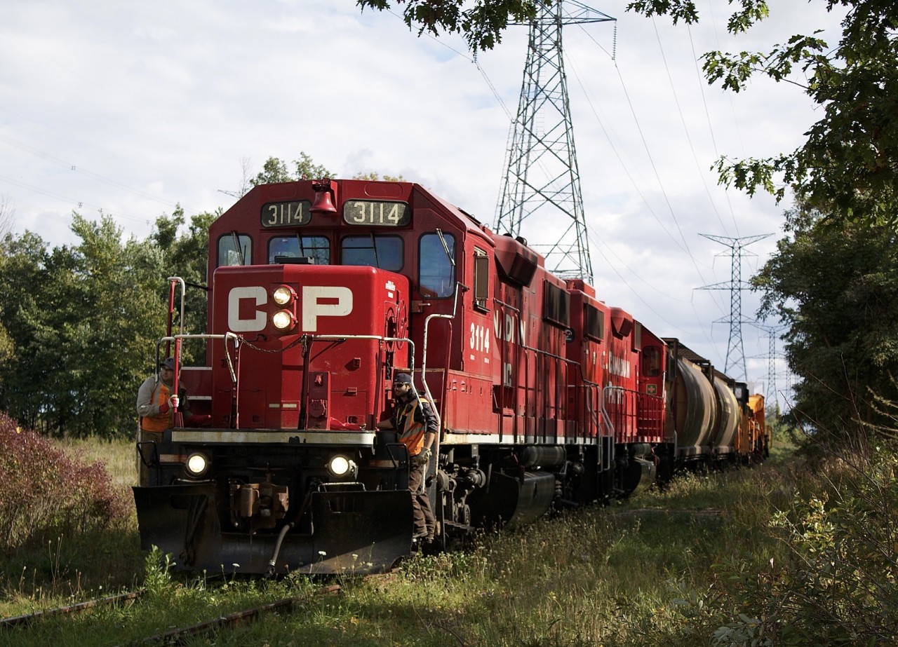 To say train movements on the Hornby- Hydro spur are rare would be an understatement, although for a short period it was often used for car storage, including in needed Expressway flat car sets. As far as actual transformer moves, maybe one every decant so. It’s funny how the entire almost 10 years that I lived in my first house just off 9th line I managed to miss 2 such moves. This I believe was the last train so far to run on the line and I only managing to catch the empty return trip. Luck was on my side this day as I was outside with my real estate agent taking photos of my house going up for sale and heard a horn where I had never heard one before. Knowing the empty cars were  sitting at the hydro facility for over a week it had to be the power coming to pick them up. In this shot the two GP38’s have two covered hoppers used as buffers, a van and the empty transformer car in tow as they slowly roll along the weed chocked spur and head back to the main. The train is about to cross Britannia Road. Today the spur remains but has been unused for anything since this photo was taken.