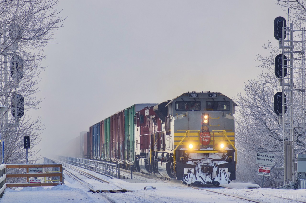 A Late CP 253 is approaching the end of its journey as it enters the island of Montreal on this cold morning. The original crew ran out of hours and had to be took over by a St-Luc crew. The fog seen in the back is covering the St-Lawrence river.