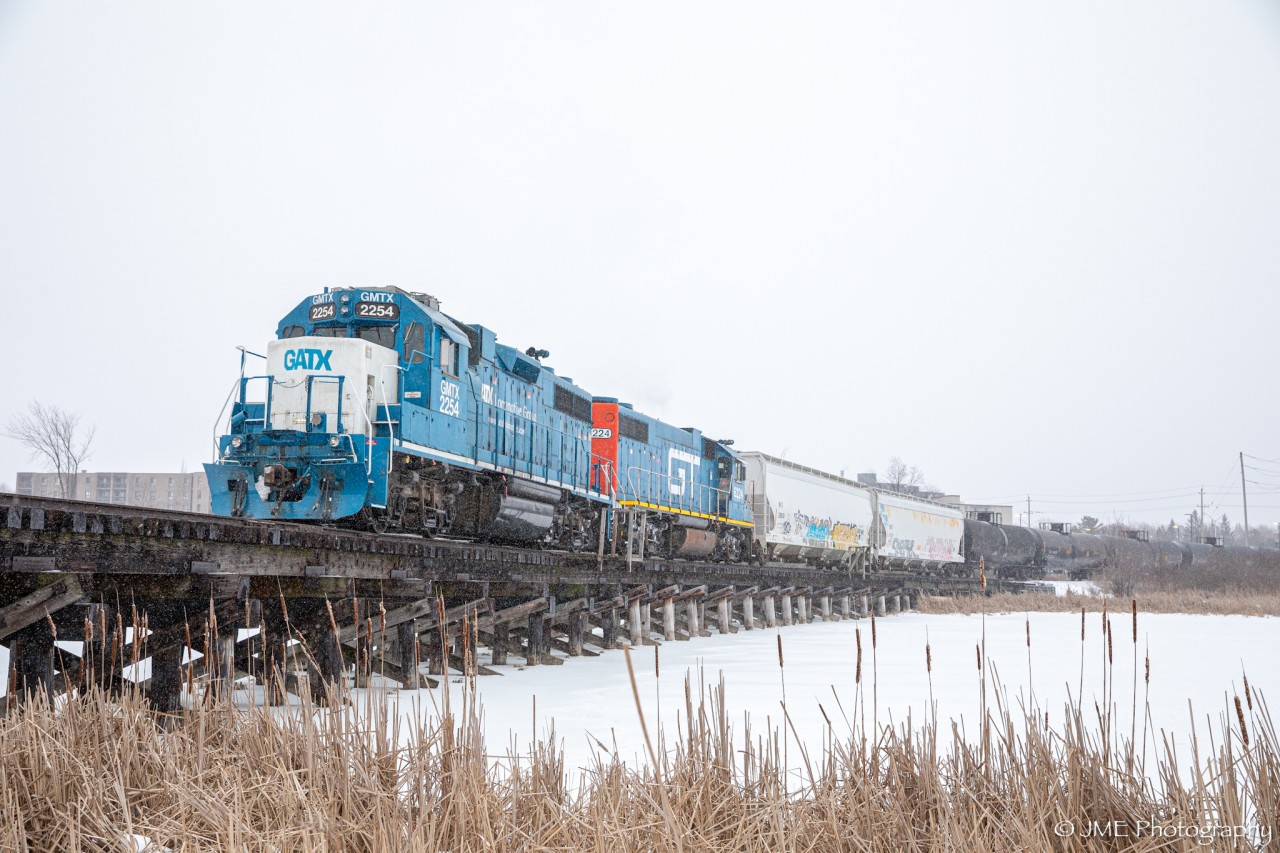CN L518 backs up towards Invista, as they cross a little wooden trestle going across the Little Cataraqui Creek, in Kingston ON. Up front is GMTX 2254, & a surprise visitor (GTW 6224). Apparently the heater on the GTW wasn’t working, so the whole time the GMTX had to lead per crew preference, so when the GMTX came in leading eastward, heading westward they wyed the train at the Kimco Wye at Queens.