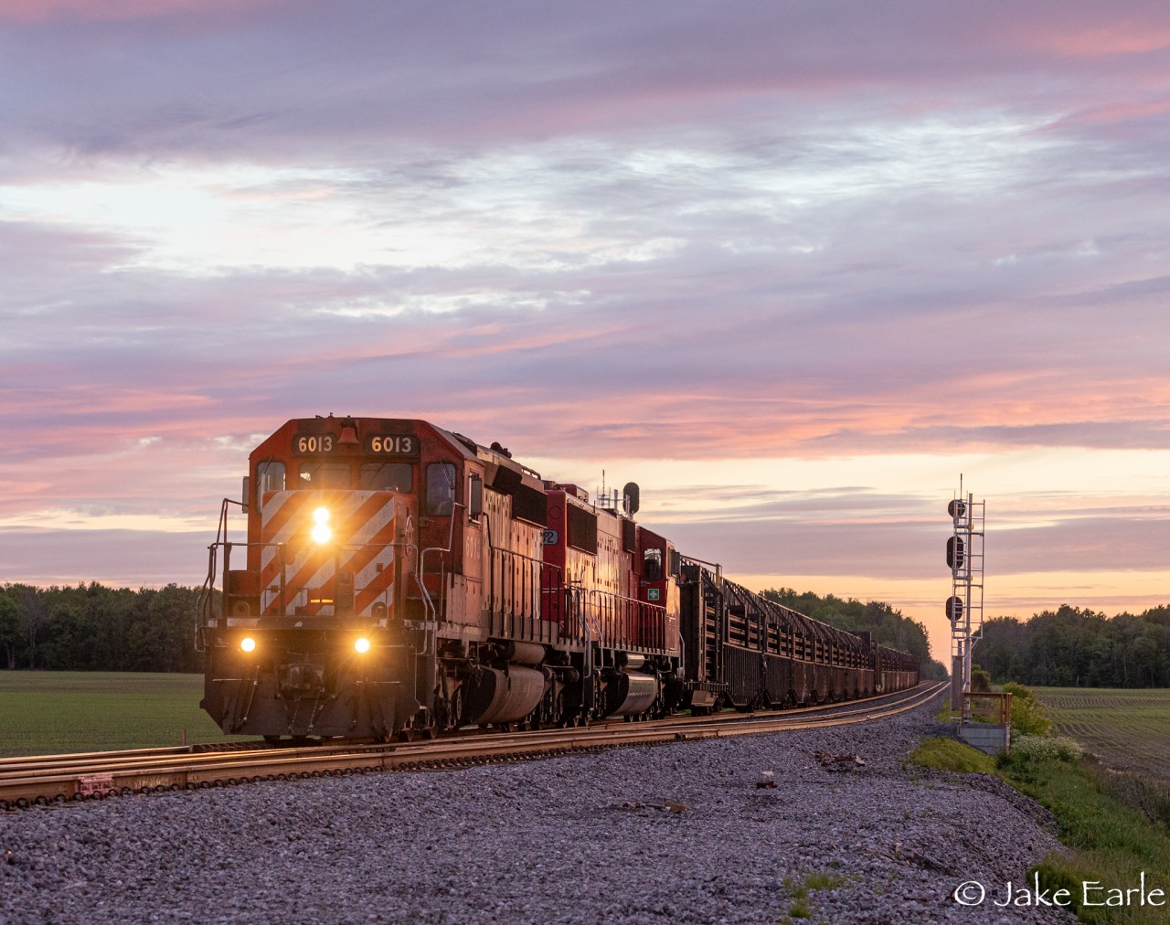 As I got word that there was a CWR headed eastward from Smiths Falls to Montreal on the Winchester, I was kind of hoping it would come sooner in Green Valley ON, but I had to drive a little further west since I was losing light. Luckily I got this train at just the right lighting, and the right angle at Avonmore.

This CP CWR train passes through the country side of Avonmore ON, with a pair of SD’s hauling loads of Continuous Welded Rail bound for the former CMQ I do believe. Weeks later, this train would drop off Rail on the Belleville Sub, with the SD60M taking the lead.