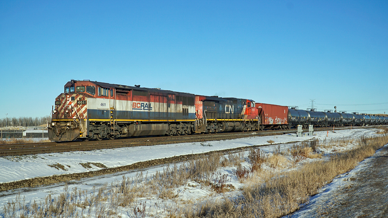 Dash 8-40CMu BCOL 4611 and Dash 8-40CW CN 2562 head west through Clover Bar with an oil train.