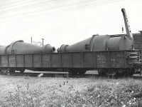 Completed "Cyclone Separators" have been loaded into Gondola 142320 on the spur that lead through the Sherk Lumber property to the rear (north side) of Port Colborne Iron Works / E.B. Magee, a custom fabricator, boiler  shop and sometime Great Lakes ship builder.  Cyclone Separators are generally used in dust / pollution control applications and would have been considered newer / greener technology at that time.  It appears that the spur had at least 2 tracks with the mobile crane parked between the gon and the steel boxcar.  142320 was built in Dec 1942 and is a riveted steel construction.  The gon looks to be labeled both "Welland" and "Magee" (illegible) on the east and west ends respectively.  The Port Colborne Iron Works closed in the early 2000's, and the current building occupant is an unrelated company, LA Steel.  The spur to the plant through Sherk Lumber was removed in/around the time PC Iron Works ceased operations.   