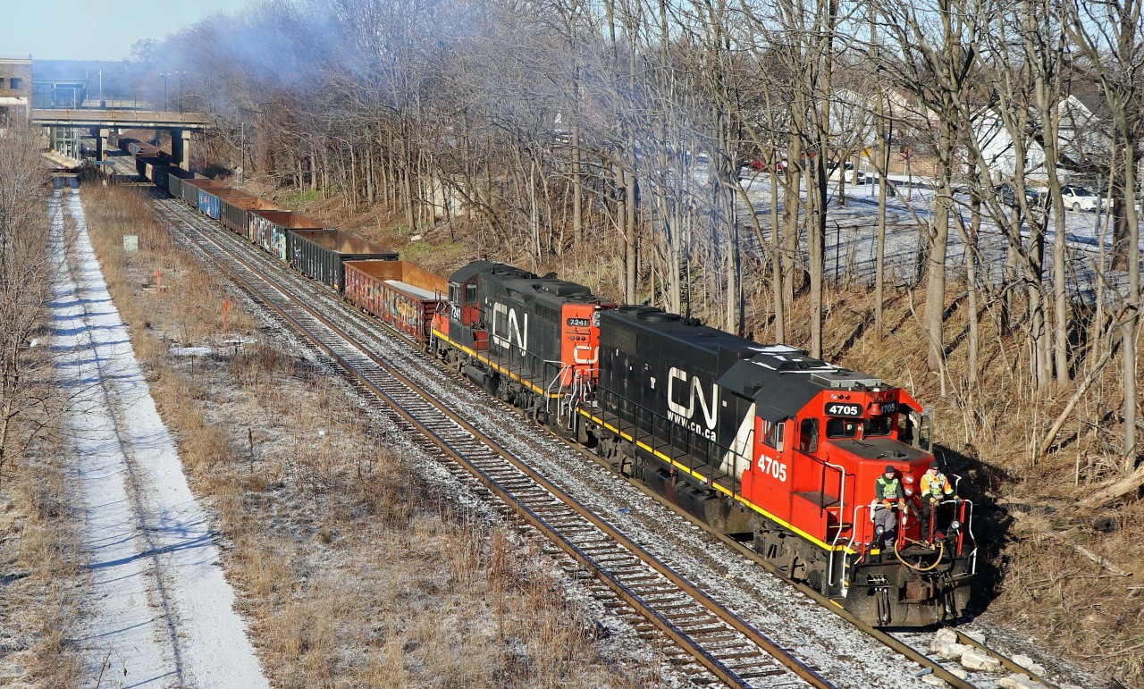 "Steeltown". "The Hammer". For railroaders, these names bring to mind heavy, slow drags with cars of steel (gondolas, coil cars, flats) and other industrial cargo. Here we see 0800 Hamilton Yard assignment heading towards "the hole" (N&NW spur) with a sizable number of gons. Yesterday when I saw this job, they returned to Stuart Street with something like 40 cars and 5600 tons--no wonder they use two or three unit sets of old road power such as GP38-2 4705 (ex 5505)and 7241 (rebuilt for yard service from GP9 4311)! To see the same location in 1975, http://www.railpictures.ca/?attachment_id=47735 .