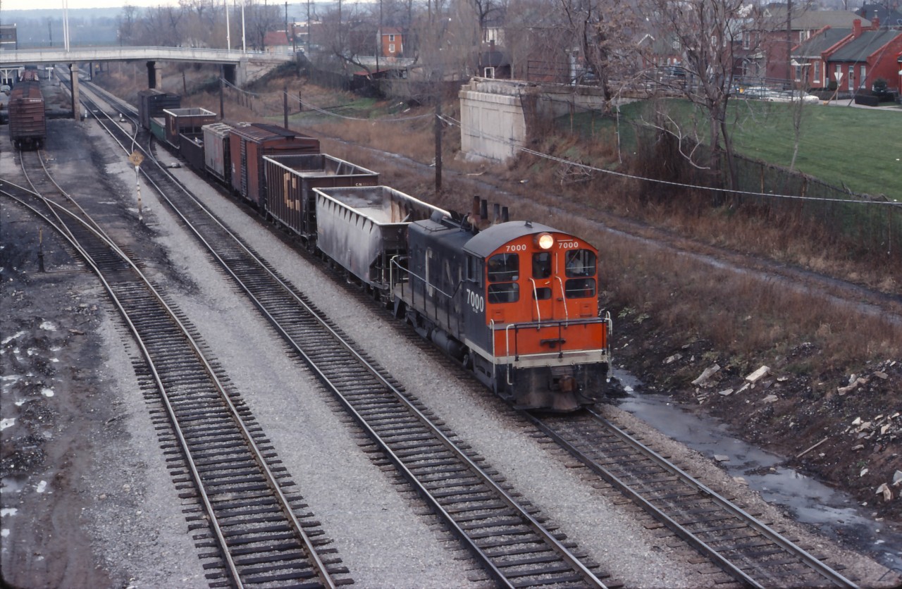 With class unit 7000 on the point, a yard assignment moves along the North Track of the Grimsby sub headed into "the hole" to serve industrial customers. At the time, most yard engines in Hamilton were MLW S4s supplemented by a couple of GM units assigned to "out posts" such as Brantford and Oakville. By the mid-1980s, SW9 and SW1200 locomotives would hold down most assignments (and SW1200RS units into the mid-1990s).