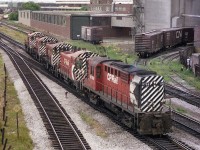 This image is of a CP power move that came up from Parkdale and heading west on the Galt sub, as seen from the old Weston Road bridge. Power visible is CP 8768, 8146, 7043, 7060 and 7024.  The three 7000-series MLW S-2 switchers were all retired by 1986. On the north (upper) side can be seen two leads to the Maple Leaf Mills plant as well as a one to a warehouse.  Most all of this industrial area has been demolished beginning 1992 or so and has been replaced by condo towers. This view is but a few hundred yards west of the old classic West Toronto Diamond; a hangout for many of us in the days gone by.  Now? Fergit it.