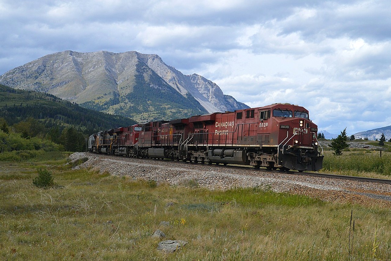 CP eastbound with lots of power up front; always appreciated...CP 8839, 9812, 9353, 7013 (heritage) and UP 5512 was really moving and put us to the test to catch it, as it was rolling east and we spotted it while driving west.  So, backtracked to this crossing. Not taking chances on going further because there were a lot of slowpokes on the highway.... In the background you can see the collapsed mountain, the infamous "Frank Slide" of 1904 in which the whole side of the mountain came down in the night and buried the town of Frank.....killing many people as well as burying the railroad.  Many stories float around about this disaster, including those regarding steam engine(s) buried under what seems like incredible amounts of rock.  Stunning. Photos do little justice. This disaster location must be seen in person........many of the rocks are the size of locomotives........