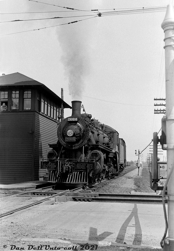 Canadian Pacific G2u "Pacific" 2664 (a Lambton Yard assigned steam engine, possibly on the Trenton Pickup job) works CP's yard at Oshawa, crossing the diamond with the Oshawa Railway under the watchful eye the leverman in the adjacent interlocking tower. Note the overhead catenary for OR's electric operations. Built by CP's Angus Shops in June 1914, 2664 ended her days working out of Lambton Yard until the end of steam, and was scrapped at Angus in March 1961.

The Oshawa Railway was an electric railway owned by GTR/CN that served the town of Oshawa, and interchanged with both CN and CP. It played an important part serving the automotive industry, including northern GM plants in town (notably the GM Oshawa North Plant (truck plant)) that were accessed via streetrunning trackage through town. CP and CN both interchanged cars of automobile parts to the Oshawa Railway for forwarding to the GM plants and associated automotive industries it served. CN de-electrified the line in 1964 and the old Oshawa Railway electric "motors" were retired. CN's GMD SW units were the usual power until most of the "Oshawa Railway Spur" was abandoned in the 1990's. The current OR right-of-way is home to the Michael Starr Trail.

Original photographer unknown, Dan Dell'Unto collection negative (large-format scanned with a DSLR).