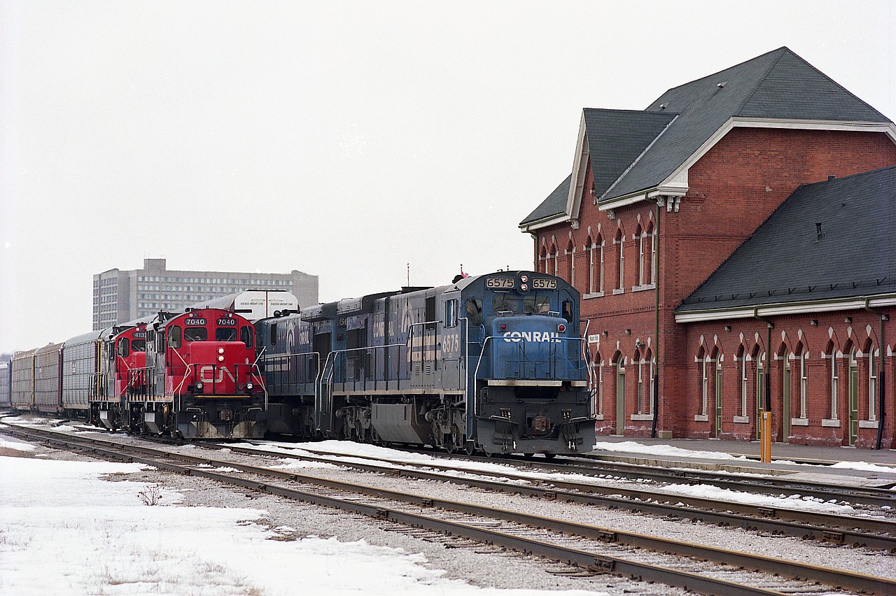 Noticeable sinking in the Niagara River of one of the support piers of the International Bridge at Fort Erie led to some emergency 'shoring up' in early 1993. The result was daily transfers and regular traffic had to detour thru CN Niagara Falls, making for some entertaining days around the otherwise usually quiet VIA station. In this particular view, off to the left is CN yard jobs 7040 and 4137 wait while CR 6575 and 6629 bring a long string of empty autoracks over to Canada before returning to the US as a lite move.