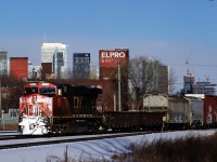 CN 2811 has a lot of snow on its nose as it leads CN 305 past the skyline of downtown Montreal.