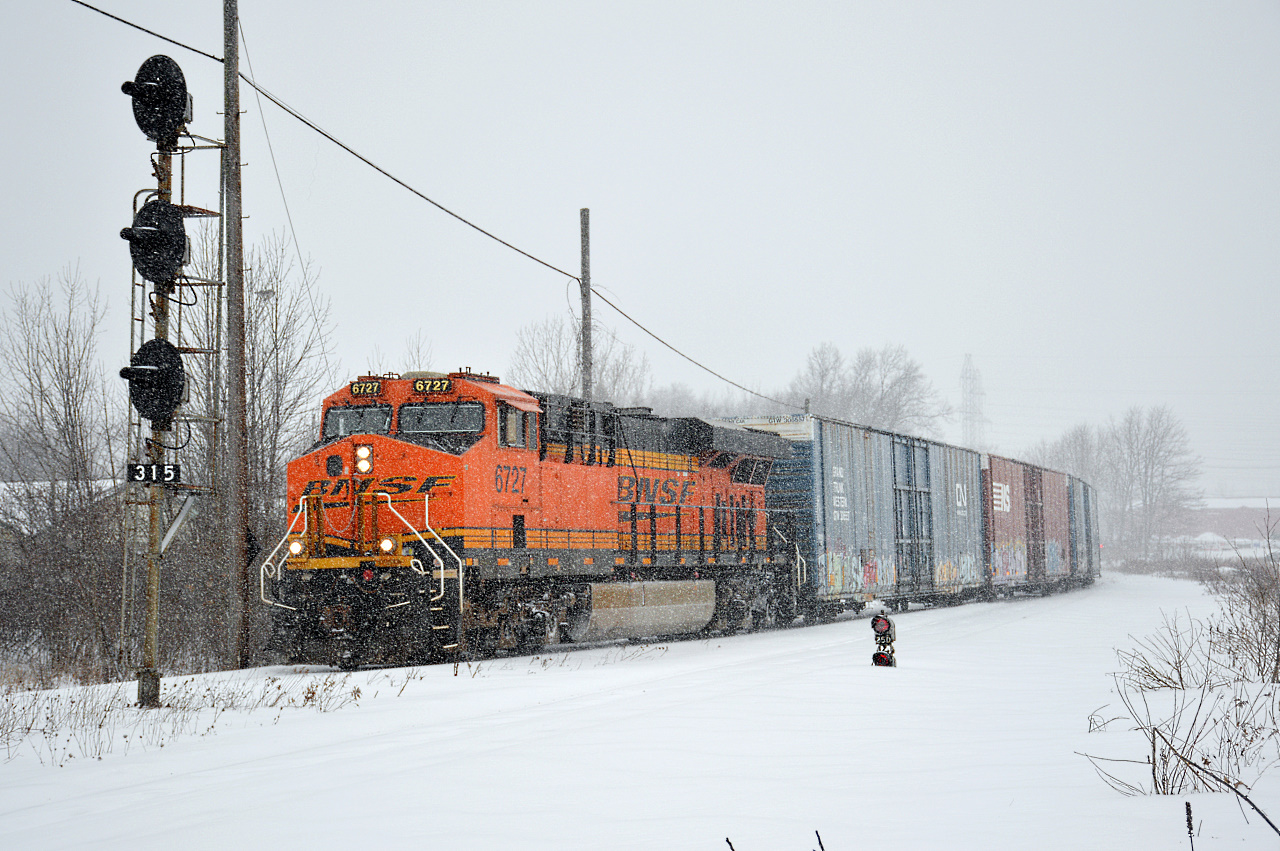 BNSF GE ES44C4 #6727 leads CN L523 solo through CN Clifton, coming off the Grimsby Sub and onto the Stamford Sub during heavy snowfall in Niagara Falls, Ontario.