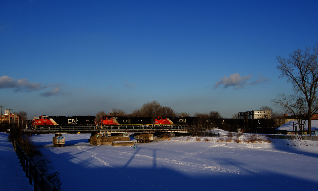 CN 305 has three units elephant style up front (CN 3907, CN 2514 & CN 8813) as it crosses the Lachine Canal a bit before sunset, as well as CN 2988 mid-train. In a couple of miles the two trailing units will be set off at Turcot Ouest when the train changes crews.