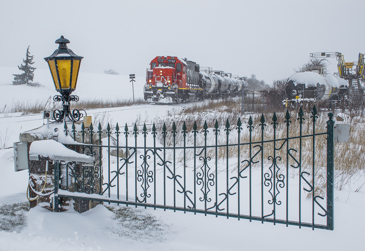 CN L542 pauses on the Fergus Spur just outside FloChem while the conductor and trainee meet with the yard foreman to discuss spotting the inbound cars.  Their 15 minute break allowed plenty of time for a farmer to finish plowing his driveway which crosses both the Fergus Spur main track and the FloChem siding.  Shortly, 4732 will cut off from it's train and run ahead to the switch for the crew to sweep it out and start their work.