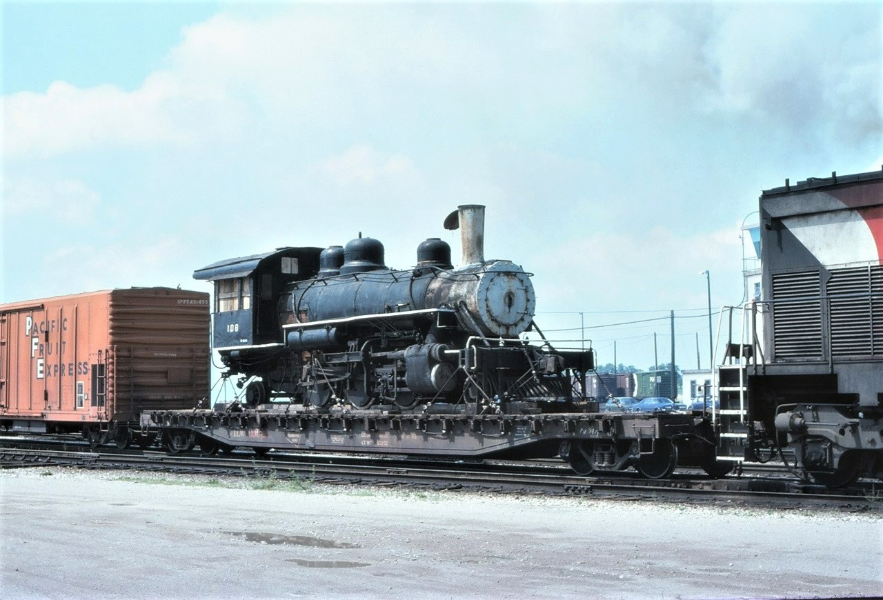 Ex Reader Railroad 108 passing through CP's Agincourt Yard on its way to its new home at Conway Scenic Railroad on July 4 1976.  108 was built by Baldwin in 1920 as San Augustine County Lumber #108. It then went to the Angelina and Neches before going to the Reader in 1954. After a boiler failure and a number of years on display at Conway Scenic it apparently was sent to Texas in 1999, but I could not determine its current location or condition.