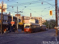 <b>Morning in the Leslieville neighbourhood:</b> residents head off to work, some with lunch boxes in hand, as a pair of MU'ed TTC PCC streetcars pause at the light eastbound on Queen at Coxwell. The lead car is TTC 4663 (A11-class, originally built 1946 for Cleveland), with a TTC 4400-series car (A7-class, new to the TTC in 1949) coupled behind. Both classes were equipped with couplers for MU service, originally for the busy <a href=http://www.railpictures.ca/?attachment_id=39089><b>Bloor streetcar</b></a> route, and later migrating to service on Queen. In the distance, another two eastbound PCC cars approach.
<br><br>
Today, most of the low-rise storefront and apartment buildings here still remain, although the customers have changed. Stores visible in 1968 are: Jimmy's Farm (produce), George's Smoke Shop (variety), Pickin' Chicken Restaurant, Canadian Dyers & Cleaners. On the right are signs for Diamond Steak House, and Sue's Dry Goods (clothing).
<br><br>
<i>Robert D. McMann photo, Dan Dell'Unto collection slide.</i>