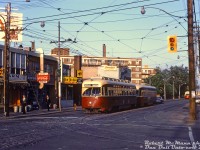 <b>Morning in the Leslieville neighbourhood:</b> residents head off to work, some with lunch boxes in hand, as a pair of MU'ed TTC PCC streetcars pause at the light eastbound on Queen at Coxwell. The lead car is TTC 4663 (A11-class, originally built 1946 for Cleveland), with a TTC 4400-series car (A7-class, new to the TTC in 1949) coupled behind. Both classes were equipped with couplers for MU service, originally for the busy <a href=http://www.railpictures.ca/?attachment_id=39089><b>Bloor streetcar</b></a> route, and later migrating to service on Queen. In the distance, another two eastbound PCC cars approach.
<br><br>
Today, most of the low-rise storefront and apartment buildings here still remain, although the customers have changed. Stores visible in 1968 are: Jimmy's Farm (produce), George's Smoke Shop (variety), Pickin' Chicken Restaurant, Canadian Dyers & Cleaners. On the right are signs for Diamond Steak House, and Sue's Dry Goods (clothing).
<br><br>
<i>Robert D. McMann photo, Dan Dell'Unto collection slide.</i>