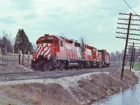 <br>
<br>
   The Seventies C P Rail ...
<br>
<br>
   ….when every lashup was an adventure in motive power variety..... 
<br>
<br>
    ….GMD – GMD - MLW combo: GP35 and SW1200RS is assisted by a  MLW  'ugly 80'  RS-23
<br>
<br>
     accelerating on the downgrade at the Campbellville Road crossing, April 7, 1979 Kodachrome by S.Danko
<br>
<br>
   Note the location of 5006's marker lights ... a GP35 leading ! ? !
<br>
<br>
   Given no flags, no markers illuminated, this is a regularly scheduled train, likely this is fourth class  #52 (?)
<br>
<br>