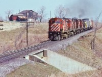 <br>
<br>
   The Seventies C P  ….   … that is CP Rail a division of Canadian Pacific Limited...
<br>
<br>
   ….when every CP Rail train was an adventure in motive power variety..... 
<br>
<br>
    ….and  MLW  Power  Ruled !
<br>
<br>
    two C424's (#4203, 42x6), two RS-18's, a RS-3 (#8459) power a regular scheduled westbound, likely #915, with two in transit ex CP Rail VIA FP7A's ( VIA 1416, 14xx),  
   <br>
<br>
     near milepost 160 Belleville Subdivision, April 29, 1979 Kodachrome by S.Danko
<br>
<br>
   noteworthy....TOFC loads on the head end....
<br>
<br>
   ...the ex CP Rail  VIA 1400's (and  ex CP Rail VIA 1900's)  were a common sight on the Belleville Subdivison as the units cycled through maintenance schedules at the CP Rail Montreal shop, 
<br>
<br>
   the in transit F's would cease June 17, 1979 when VIA trains 1 & 2, Canadian Canadien, commenced origination from Montreal's Central Station, 
<br>
<br>
   (and concurrently VIA trains 3 & 4, Super Continental, commenced origination from Toronto Union Station), 
<br>
<br>
   by that time the Budd built dome cars: ex CP Rail Skyline and ex CP Rail Park cars were cleared to enter MCS
<br>
<br>
   sdfourty