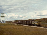 West of Grande Prairie, NAR ran a thrice-weekly wayfreight to Dawson Creek, BC, west Monday, Wednesday and Friday, and returning the next day, almost always with a single GP9.  Here, No. 51 engine 206 on Wednesday 1977-09-21 has three Hart cars of ballast and four empties plus caboose 13006 and is passing the Foster’s elevator at Albright, with 54.8 miles yet to go to Dawson Creek.

<p>Note the green reflectorized target on the switchstand, not centred on the shaft as is common, but offset to the side of the diverging track, an NAR standard that simply makes so much sense.