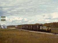 West of Grande Prairie, NAR ran a thrice-weekly wayfreight to Dawson Creek, BC, west Monday, Wednesday and Friday, and returning the next day, almost always with a single GP9.  Here, No. 51 engine 206 on Wednesday 1977-09-21 has three Hart cars of ballast and four empties plus caboose 13006 and is passing the Foster’s elevator at Albright, with 54.8 miles yet to go to Dawson Creek.

<p>Note the green reflectorized target on the switchstand, not centred on the shaft as is common, but offset to the side of the diverging track, an NAR standard that simply makes so much sense.