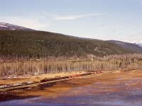 In 1974, in anticipation of the increasing water level of Kinbasket Lake behind the Mica Dam on the Columbia River, CP constructed a water-level grade between miles 61 and 66 to replace the westward dip down to Beavermouth and the subsequent climb back out of the Columbia valley.  Here, on the original mainline at 1710 on Tuesday 1974-04-23, SD40-2s 5634 + 5596 + 5822 are eastbound at the west switch old Beavermouth as seen from the new grade.