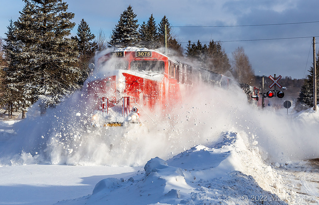 The morning after a snowfall with high winds dumped 30-40cm, 594 heads through some snow banks and drifts. I lucked out as this train never made it out of Moncton last night and had to be recrewed this morning. Seen here around mile 81 at Torryburn, approaching Saint John, NB.